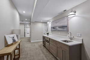 Integrated wet bar featuring a stainless steel sink, contemporary cabinetry, under-counter microwave, and beverage refrigerator