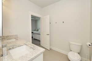 Spacious bathroom featuring a double vanity with stone countertops and undermount sinks, contemporary chrome faucets, and tile flooring