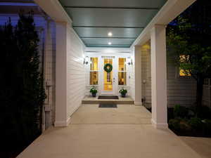 Covered front entry featuring a light blue ceiling, recessed lighting, and wall-mounted sconces