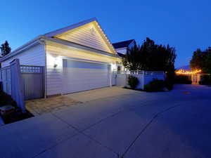 Exterior featuring white horizontal siding, an attached garage, and a concrete driveway