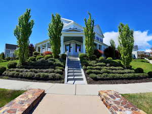 White two-story residence with a covered front porch and central staircase