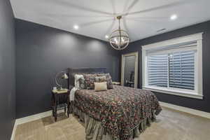 Bedroom featuring dark gray walls, white trim, and light beige carpet