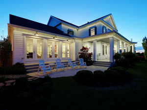 Exterior with white siding and multiple sets of French doors opening to an outdoor patio