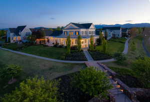 Colonial-style residence featuring a prominent two-story portico with columns, a wrap-around porch, and multiple dormer windows
