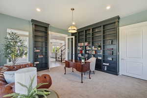 Room featuring extensive built-in shelving, recessed lighting, and a neutral carpeted floor