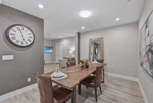 Dining space with wood-finish flooring, recessed lighting, and a neutral color palette