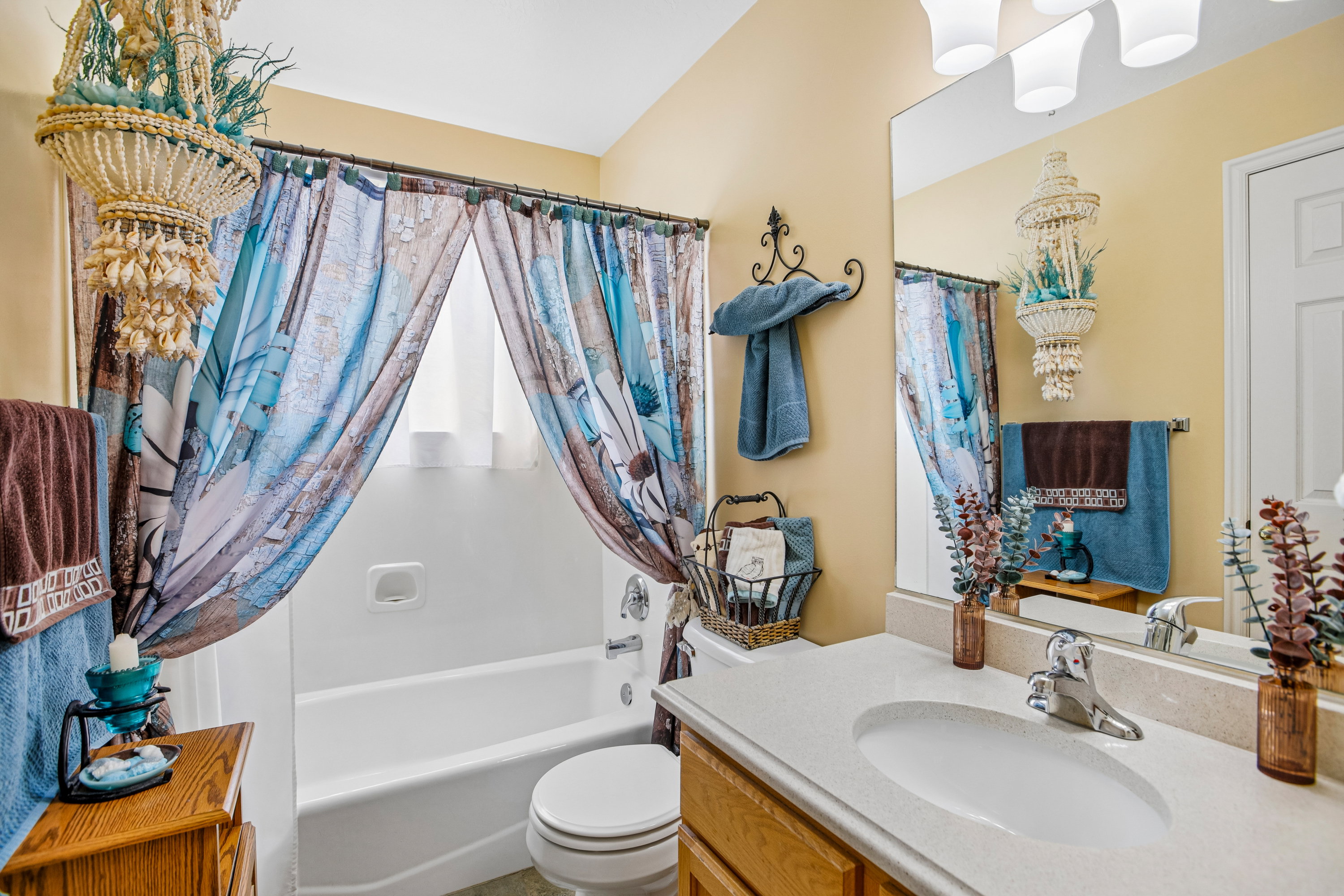 Bathroom featuring a single vanity with light-colored countertop, an integrated sink, and chrome fixtures