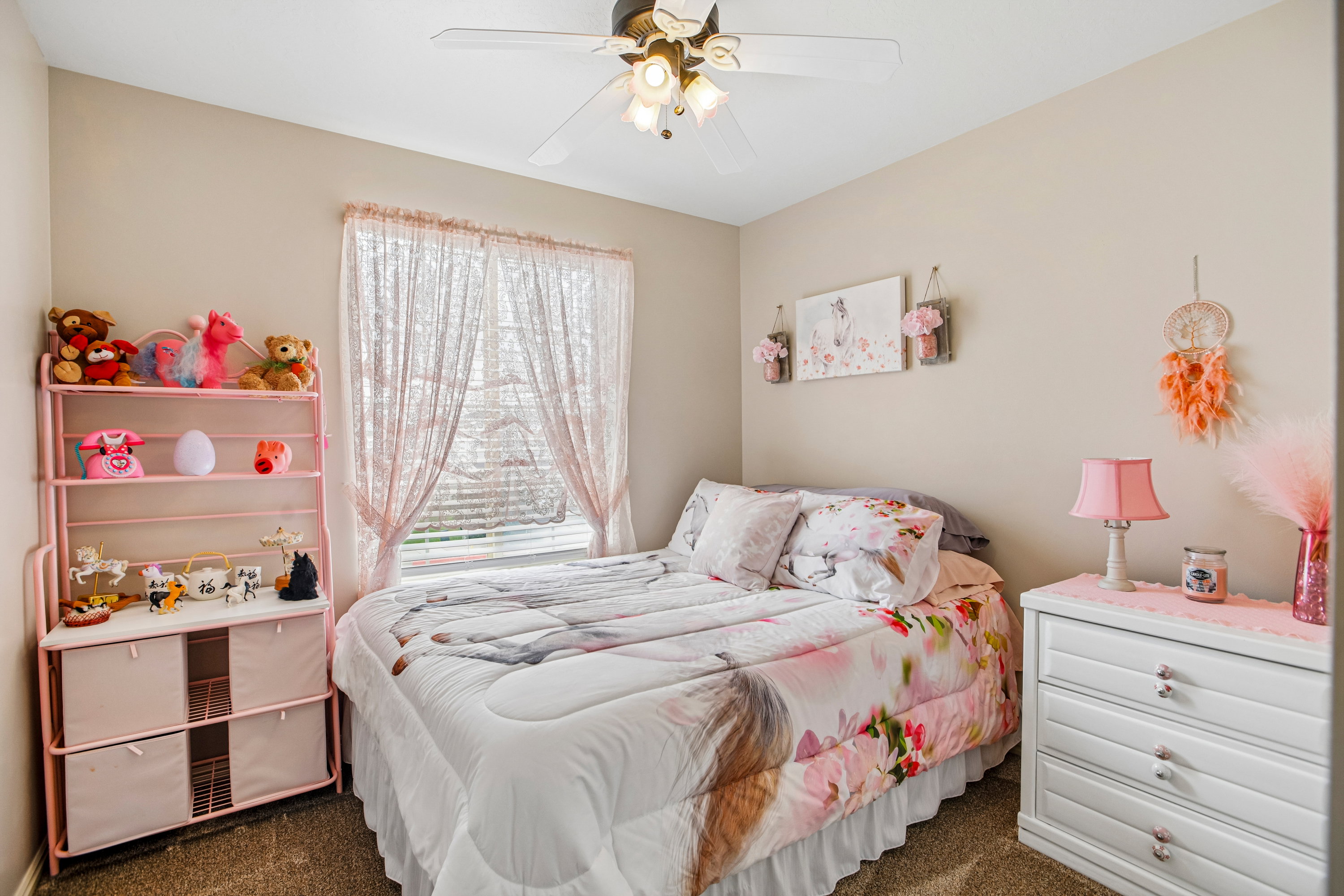 Neutral tone wall paint, textured carpeting, a window with horizontal blinds, and a ceiling fan with integrated lighting