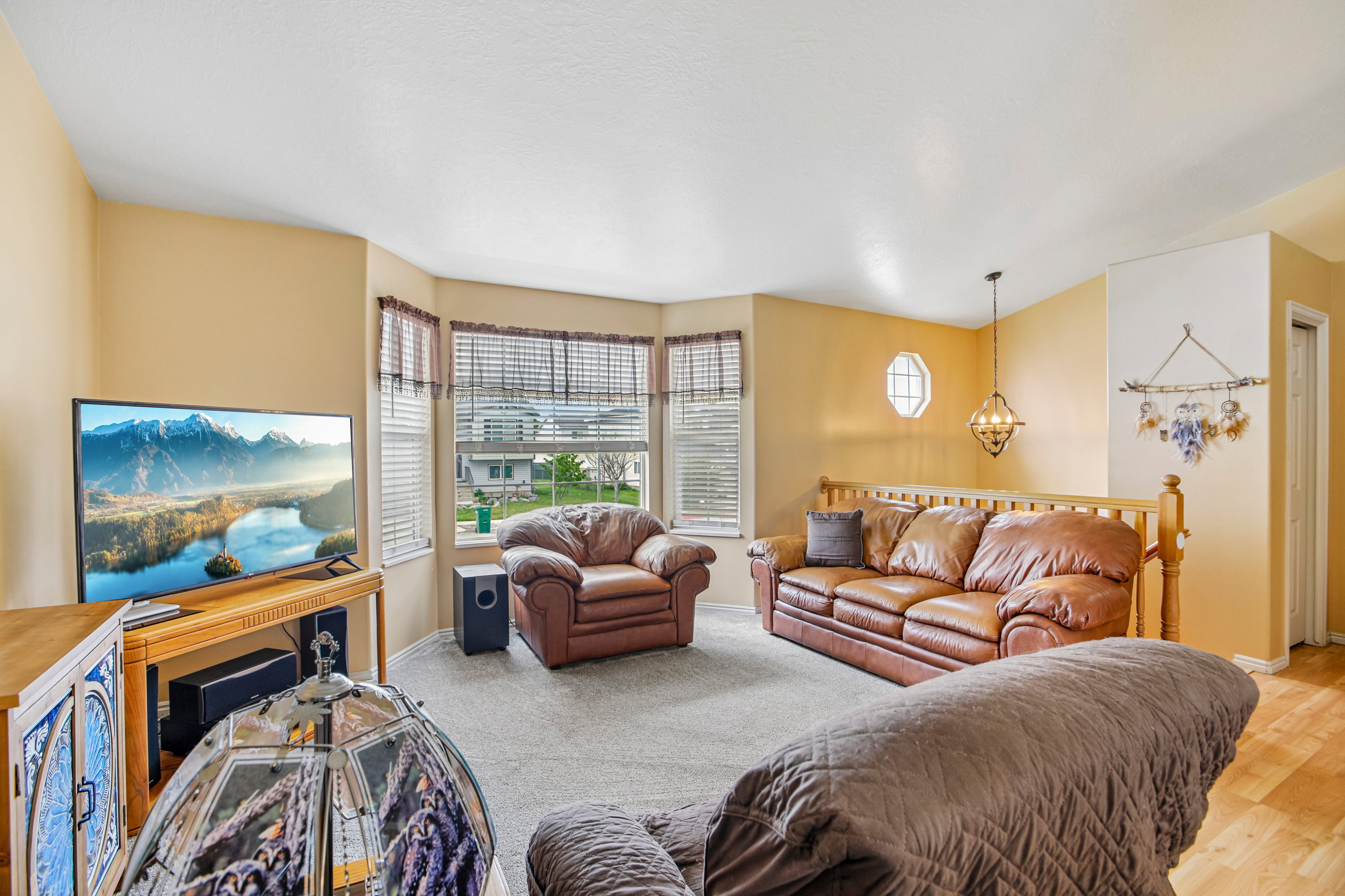 Living area featuring a bay window, neutral wall paint, and light-toned carpeting