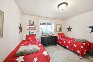 Carpeted room featuring a white window with horizontal blinds, providing natural light