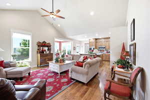 Vaulted living space featuring wood-finish flooring, recessed lighting, and a ceiling fan