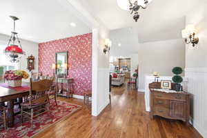 Dining area featuring a prominent floral accent wall and wood-finish flooring