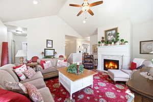 Living space featuring a vaulted ceiling with a ceiling fan