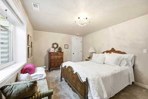 Carpeted interior with light-toned walls and a window with a white frame and blinds
