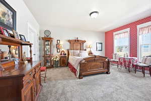 Spacious room featuring light gray carpeting and a red patterned accent wall