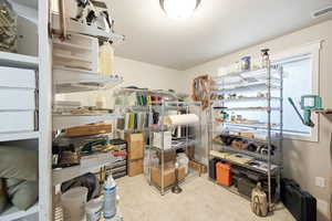 Dedicated room featuring textured flooring, recessed lighting, a single window with a privacy shade, and multiple shelving units for organization