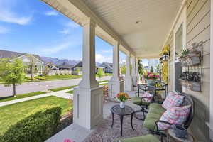 Covered front porch featuring white columns and a textured ceiling