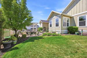 Expansive backyard featuring a manicured lawn, a large paver patio, a pergola structure, and mature landscaping