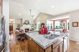 Kitchen island featuring a dual basin sink and stone countertop