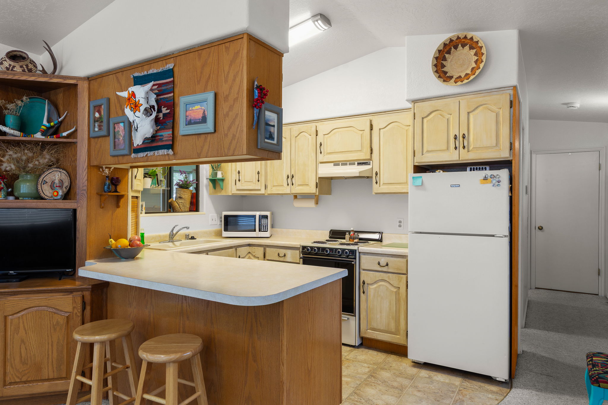 Kitchen featuring wood-finish cabinetry, a U-shaped countertop, and an integrated breakfast bar