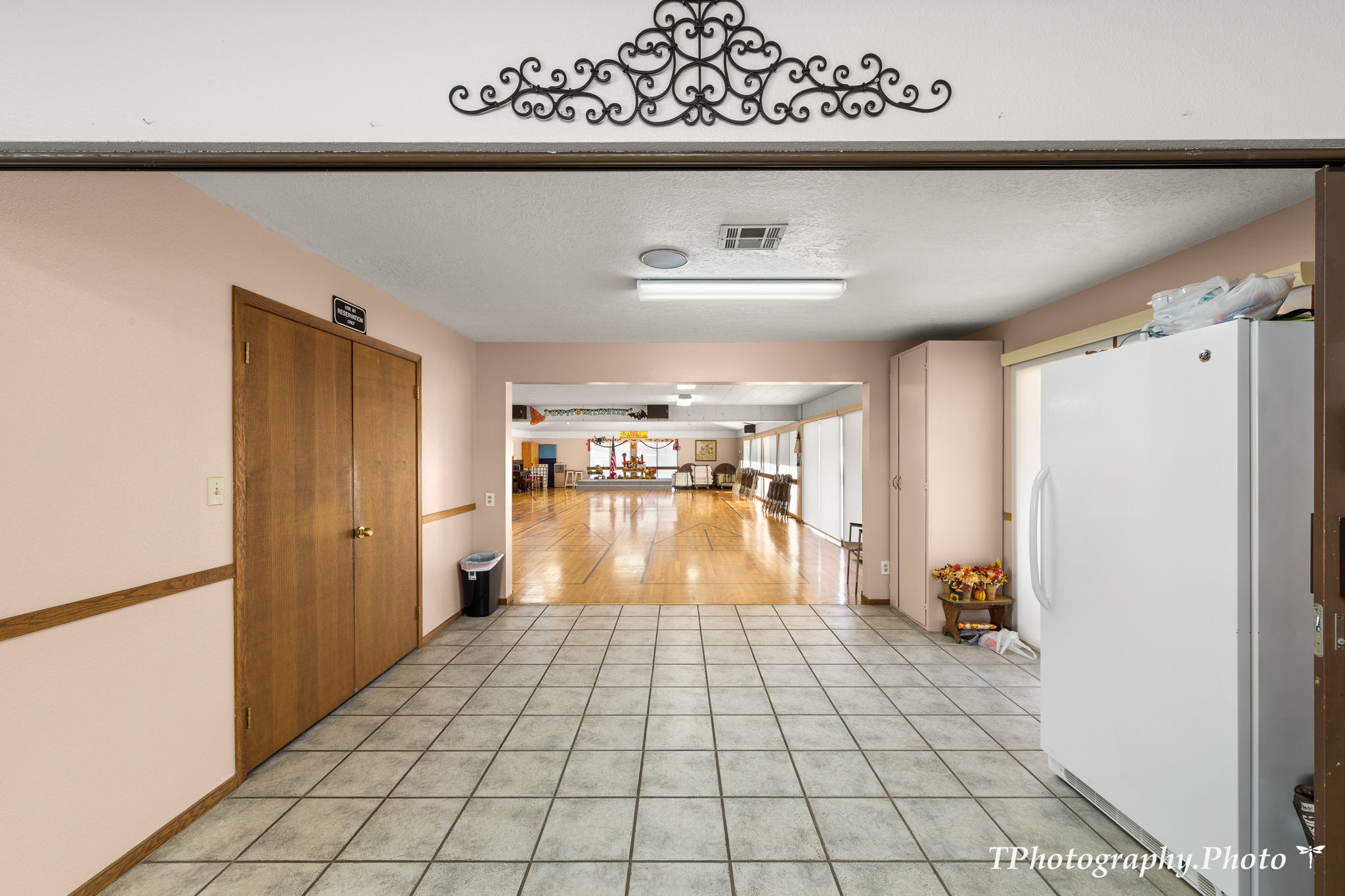 Tiled flooring leading to a spacious room with hardwood flooring