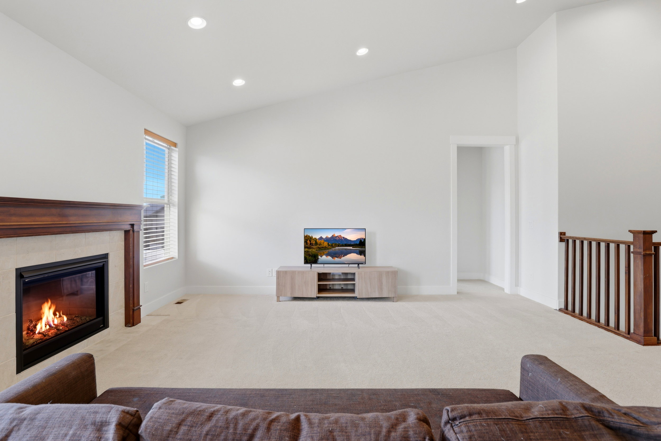 Spacious living area featuring a vaulted ceiling and recessed lighting