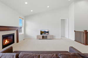 Spacious living area featuring a vaulted ceiling and recessed lighting
