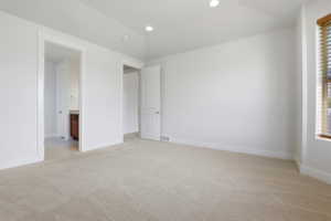 Carpeted room featuring white walls, recessed lighting, and a window with wood-finish blinds