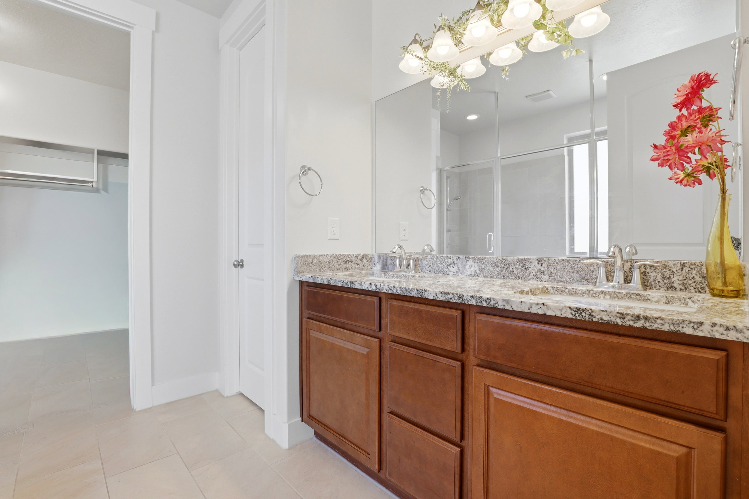 Bathroom featuring a dual vanity with light-toned countertop, integrated sinks, and ample storage cabinetry