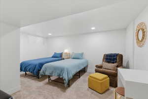 Carpeted room with recessed lighting, a horizontal window with blinds, and white walls