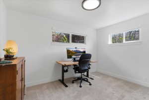 Bright room featuring neutral carpeting and white wall finishes