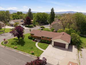 Ranch-style residence featuring a brown shingle roof, attached two-car garage with a brown door, and a concrete driveway
