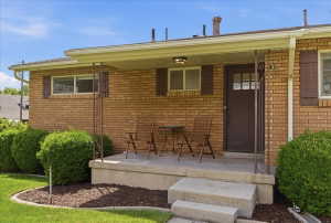 Brick exterior featuring a covered porch with concrete steps