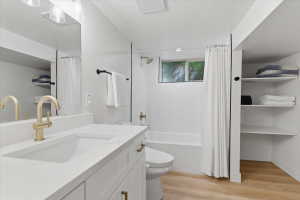 Modern bathroom featuring a white vanity with integrated sink, gold-tone faucet, and a large mirror