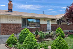 Brick and siding exterior featuring a covered front entry with wrought iron railing