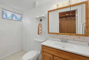 Bathroom featuring white vertical paneling, a single vanity with wood-finish cabinetry, a white countertop, and a mirrored medicine cabinet