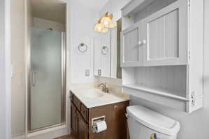Bathroom featuring a glass-enclosed shower, a vanity with an integrated sink, and an overhead medicine cabinet