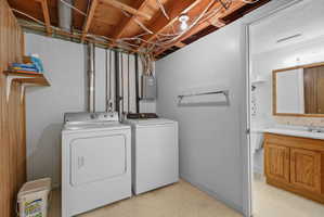 Dedicated laundry area with open wood-finish ceiling, exposed utility lines, and wall-mounted shelving