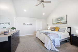 Bedroom with light carpet, ceiling fan, vaulted ceiling, and recessed lighting