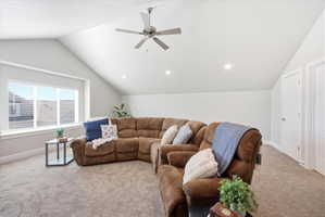 Living area featuring light colored carpet and ceiling fan