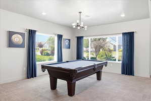 Playroom featuring carpet floors, pool table, and a chandelier