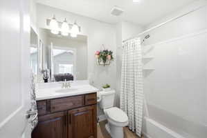 Bathroom with vanity, shower / bath combination with curtain, and light wood finished floors