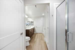 Bathroom with vanity, a stall shower, light wood-type flooring, and recessed lighting