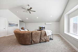 Living room with lofted ceiling, a ceiling fan, and light colored carpet