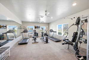 Exercise room featuring a textured ceiling, ceiling fan, and recessed lighting