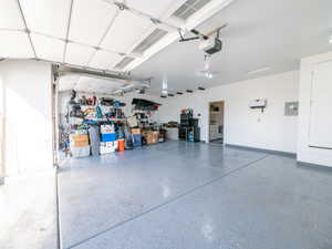 Spacious garage featuring a durable epoxy-coated floor, painted walls, and an automated garage door opener
