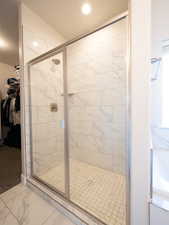 Walk-in shower with clear glass enclosure and brushed nickel fixtures
