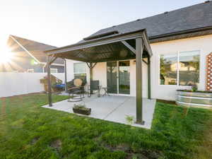 Expansive patio featuring a permanent pergola structure, concrete paving, and a sliding glass door entry