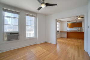 Bright living area featuring wood-finish flooring and a ceiling fan