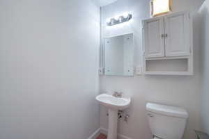 Pedestal sink with chrome faucet, framed mirror, and a wall-mounted medicine cabinet with an open shelf